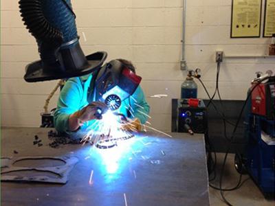 AACC art students work with metal.