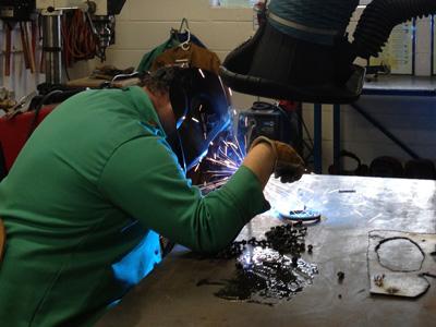 AACC student works with metal.